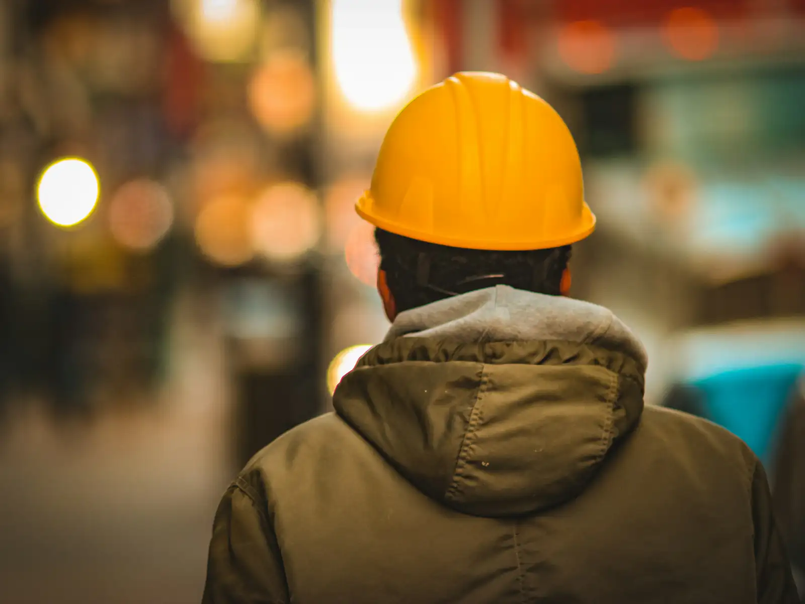 Lucrător echipat cu cască de protecție într-o hală industrială